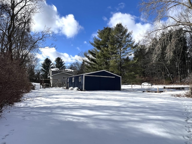 yard layered in snow featuring an outbuilding