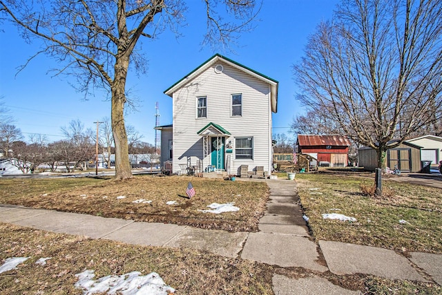 traditional home with a storage shed, an outbuilding, and a front yard