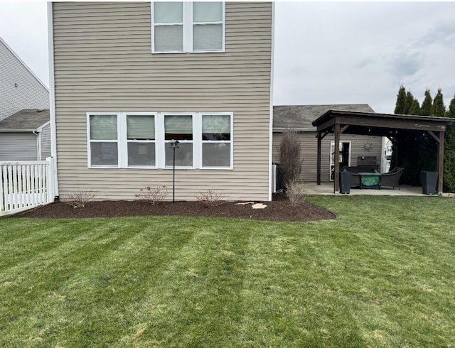 back of property with fence, a lawn, and a patio