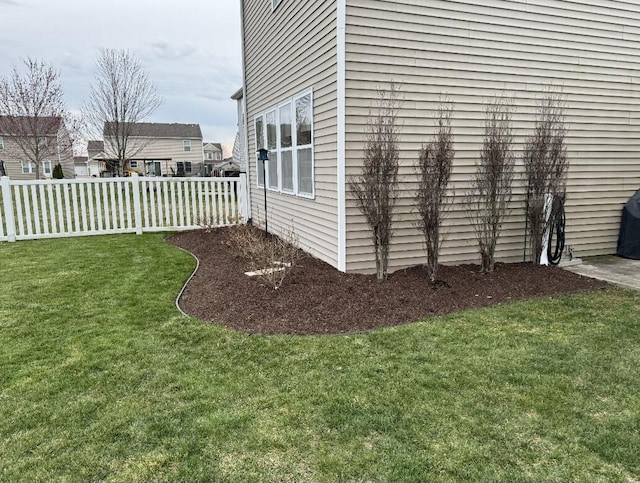 view of side of property with fence and a yard