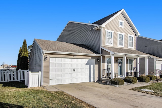 traditional-style home with roof with shingles, concrete driveway, covered porch, an attached garage, and fence