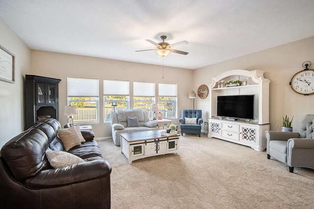 carpeted living area featuring baseboards and a ceiling fan