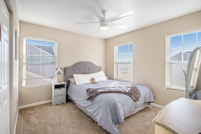 bedroom featuring light carpet, ceiling fan, and baseboards