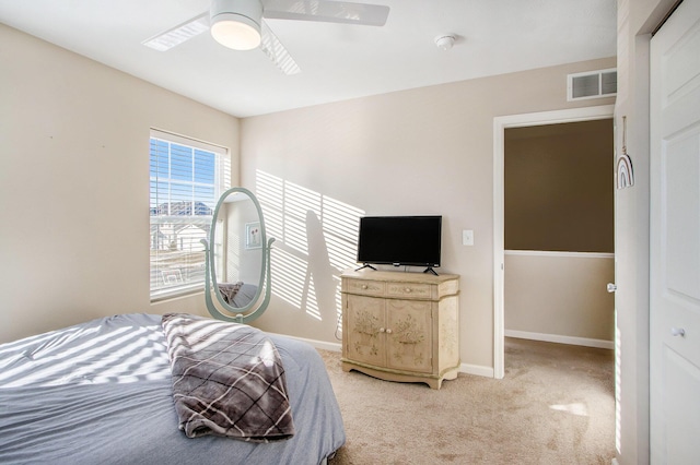 bedroom featuring light carpet, a ceiling fan, visible vents, and baseboards