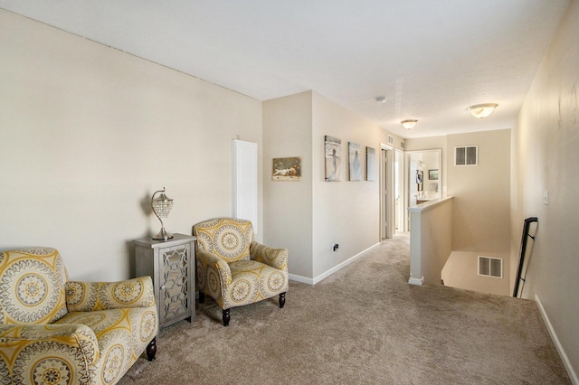 living area with carpet floors, baseboards, visible vents, and an upstairs landing