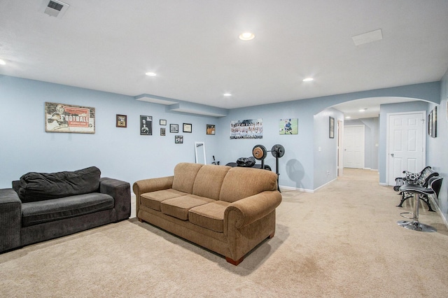 living room with light carpet, baseboards, visible vents, arched walkways, and recessed lighting