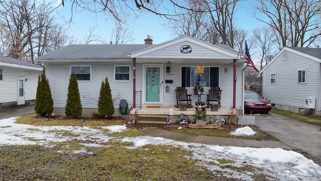 view of front facade featuring covered porch and a chimney