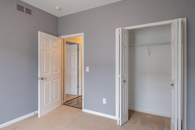 unfurnished bedroom featuring carpet floors, a closet, visible vents, and baseboards