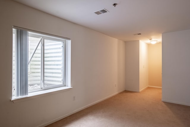 unfurnished room with light carpet, baseboards, and visible vents