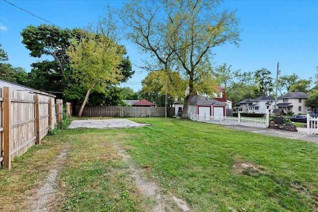 view of yard with a garage and a fenced backyard