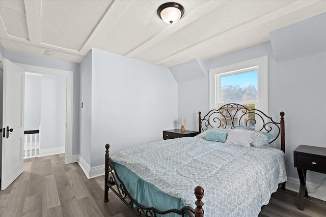 bedroom with baseboards and wood finished floors