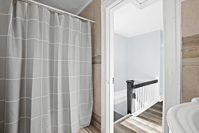 bathroom featuring curtained shower and wood finished floors