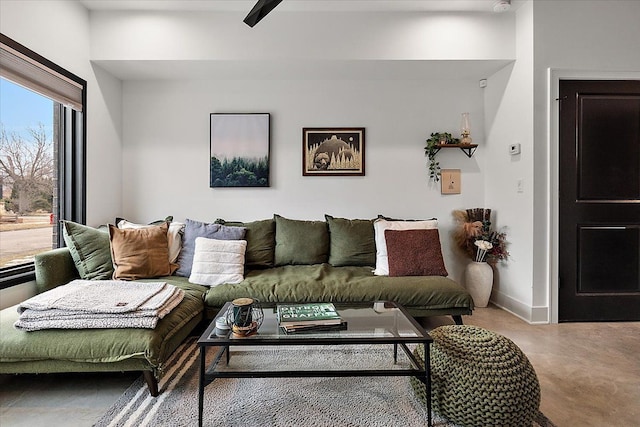 living area with finished concrete flooring and baseboards