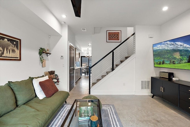 living room featuring finished concrete floors, recessed lighting, visible vents, and stairway