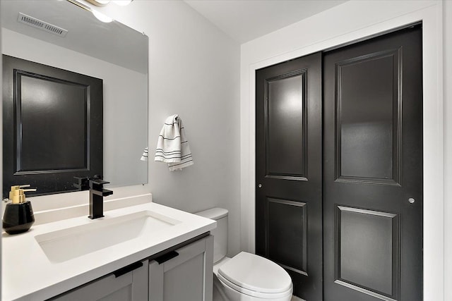 bathroom featuring visible vents, vanity, and toilet