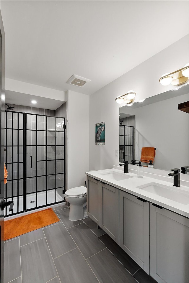 full bathroom featuring double vanity, a stall shower, toilet, and a sink