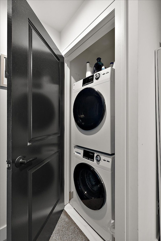 washroom with stacked washing maching and dryer and laundry area