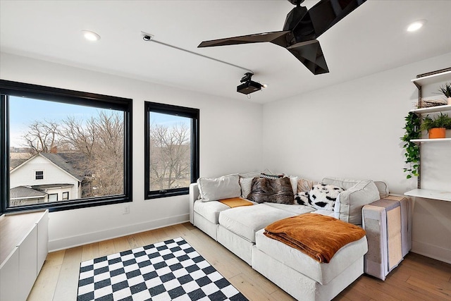 living room with a ceiling fan, recessed lighting, light wood-style flooring, and baseboards