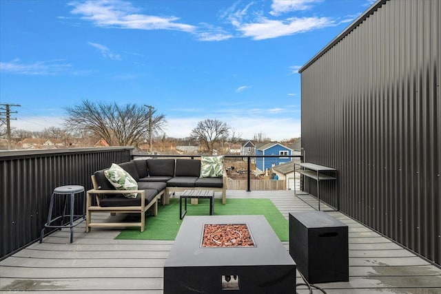 deck featuring an outdoor living space with a fire pit