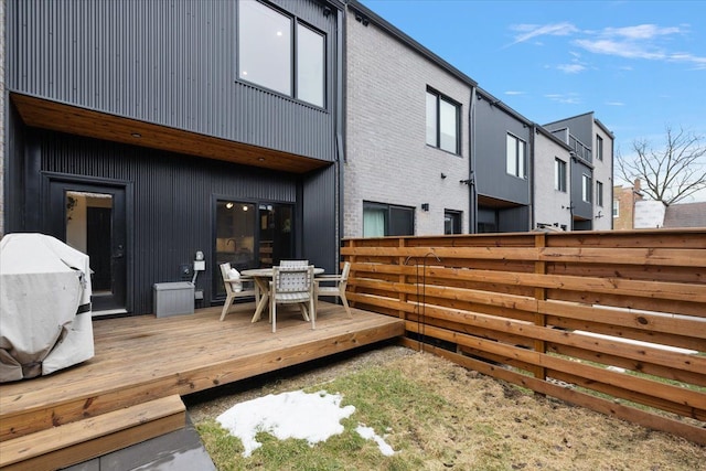 exterior space with outdoor dining area, a wooden deck, and fence