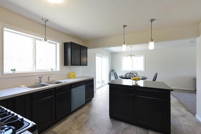 kitchen with stainless steel dishwasher, plenty of natural light, a sink, and dark cabinetry