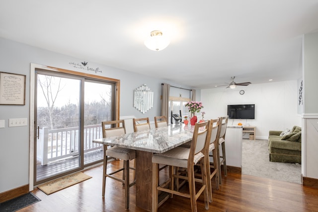 dining room featuring ceiling fan, baseboards, and wood finished floors