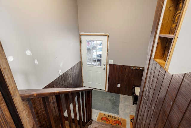 entryway with carpet floors, a wainscoted wall, and wood walls