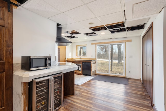 kitchen featuring wine cooler, extractor fan, a paneled ceiling, wood finished floors, and black appliances