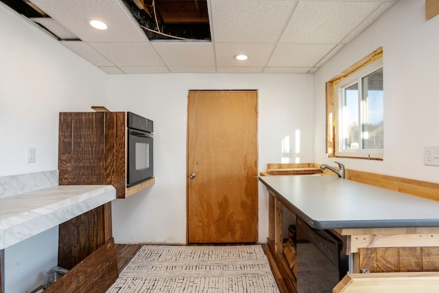 kitchen featuring black appliances, a drop ceiling, and recessed lighting