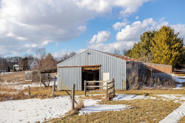 snow covered structure with a pole building and an outdoor structure