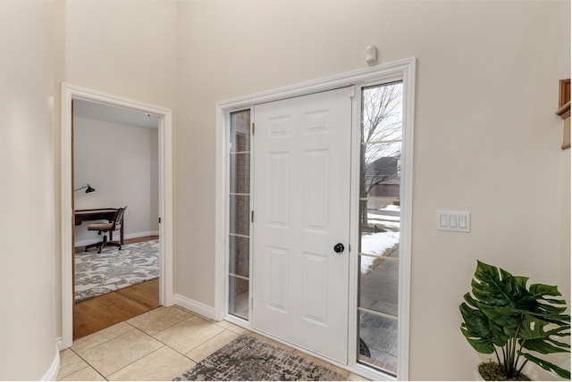 entrance foyer with light tile patterned floors and baseboards