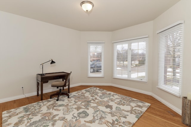 office featuring plenty of natural light, baseboards, and wood finished floors