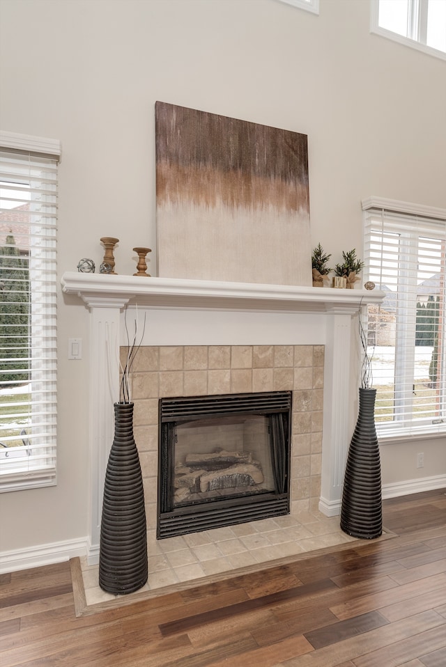 room details with a tiled fireplace, wood finished floors, and baseboards