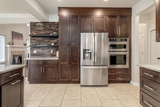 kitchen with light tile patterned floors, stainless steel appliances, dark brown cabinetry, and light stone countertops