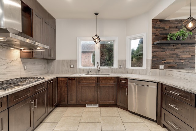 kitchen featuring dark brown cabinetry, wall chimney exhaust hood, appliances with stainless steel finishes, and a sink