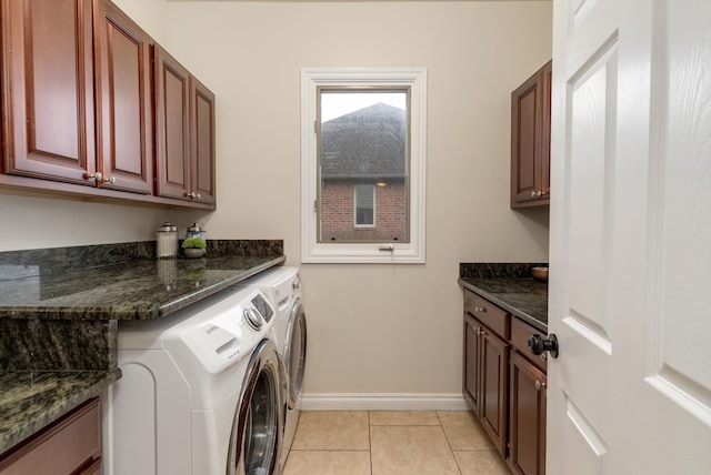 washroom with washing machine and dryer, cabinet space, baseboards, and light tile patterned flooring