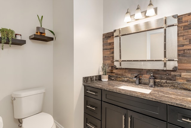 bathroom with decorative backsplash, vanity, and toilet