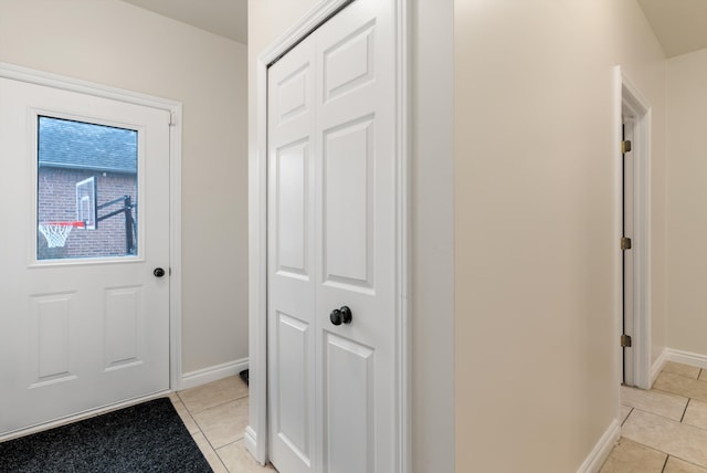 entryway with baseboards and light tile patterned flooring