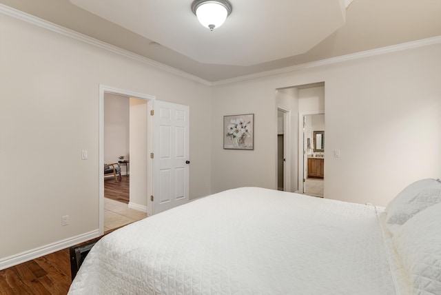 bedroom with light wood-style floors, baseboards, and ornamental molding