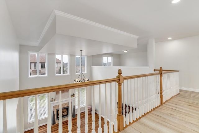 hallway featuring baseboards, recessed lighting, wood finished floors, and a notable chandelier