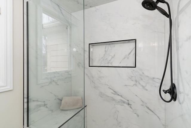 bathroom featuring a marble finish shower