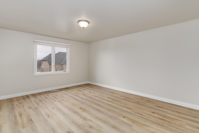 unfurnished room with light wood finished floors and baseboards