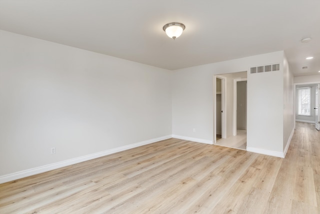 empty room with baseboards, visible vents, and light wood-style floors