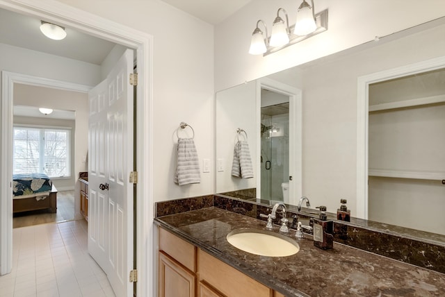 full bathroom featuring a stall shower, tile patterned flooring, connected bathroom, and vanity