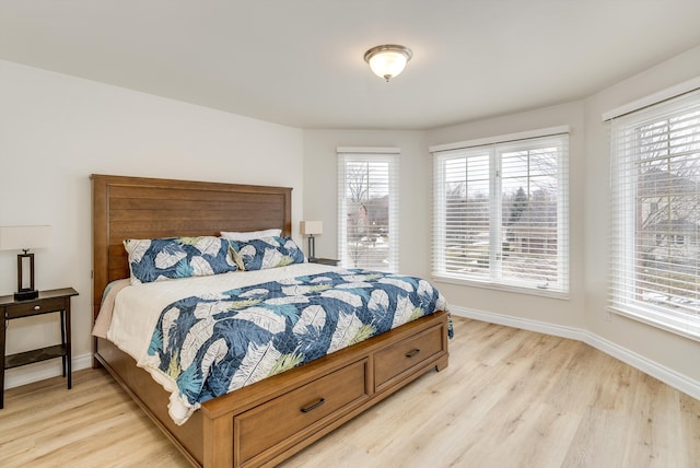 bedroom featuring light wood finished floors and baseboards