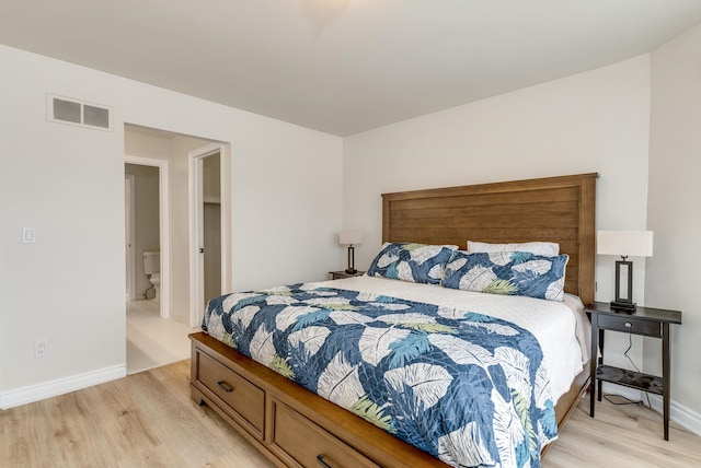 bedroom with light wood finished floors, visible vents, and baseboards