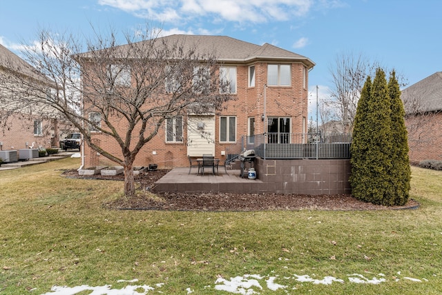 rear view of property featuring brick siding, a patio area, central AC unit, and a yard