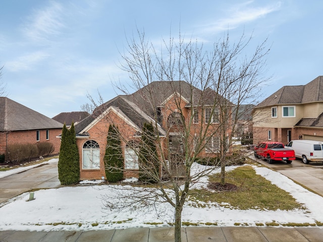 view of front of house featuring driveway and brick siding