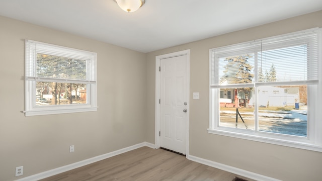 foyer with light wood-style floors and baseboards