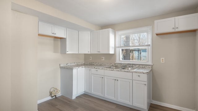 kitchen featuring a sink, light wood-style floors, white cabinets, and light countertops